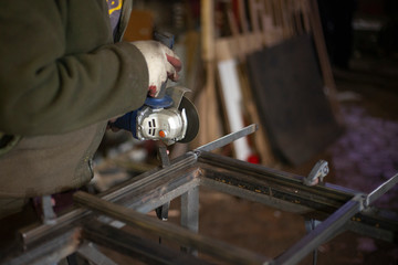 A man processes metal with a grinder.