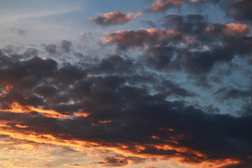 Fototapeta na wymiar The sky at sunset. Orange hues of the clouds. Background