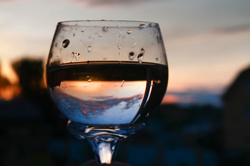 Beautiful reflection of the sky and sunset in the glass. Pleasure of rest, relaxation, quiet evening in summer.