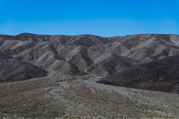 A desert landscape of barren hills of black volcanic rock