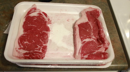 Fresh sirloin beef steak in packaging tray.