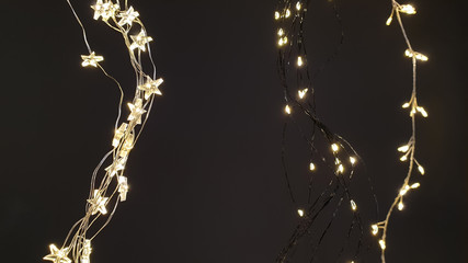 Star and sleeve Christmas lights, fairy lights hanging in a wave form next to each other on dark...