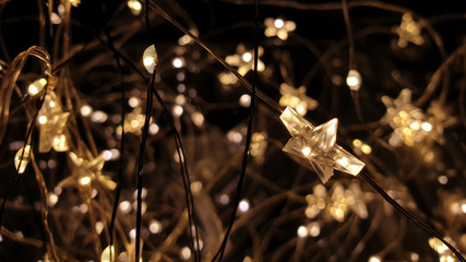 Star shaped Christmas lights, fairy lights, close up on dark background