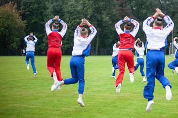 Girls gymnasts perform an exercise in the stadium.