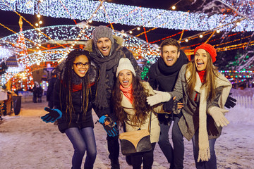 Excited friends spending time on Christmas fair