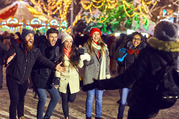 Naklejka premium Cheerful friends meeting on winter fair