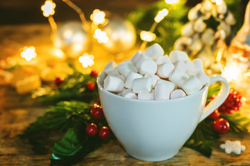 Christmas holidays wood background with Cup of Cocoa with marshmallow, luminous garland and cookie