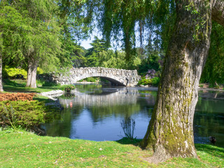A stone bridge over a pond with ducks