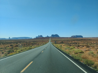 Fototapeta na wymiar A lonely road crossing through the desert towards to Navajo Land