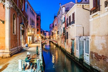 Venice view at night with canal, bridge and historical buildings