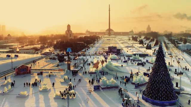 Festive New Year's Moscow with a view of the ice city with slides, a Christmas tree and landmark Poklonnaya Hill at sunset. Copter ( drone ) shooting