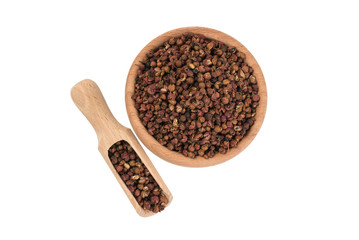 sichuan pepper in wooden bowl and scoop isolated on white background. top view. spices and food ingredients