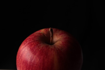 Ripe red apple on kraft paper and dark background under studio lighting