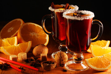 Two cups with ready mulled wine with anise, cinnamon and nuts around