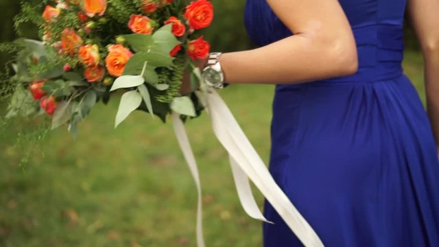 The bride holds in her hand a wedding bouquet of roses, hydrangeas, Hypericum and eucalyptus branches