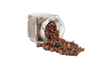 sichuan pepper in a glass jar isolated on white background. spices and food ingredients