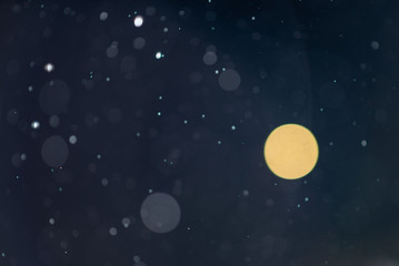 Obraz na płótnie Canvas Abstract falling snow or rain bokeh texture overlay on blue background.