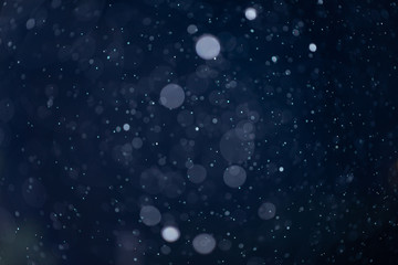 Fototapeta na wymiar Abstract snow or rain bokeh texture overlay on blue background.