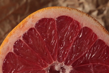 Half of grapefruit on kraft paper under studio lighting