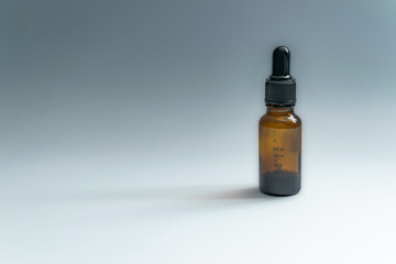 Black skincare bottle with pipette in white background with copy space.