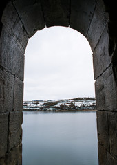 Fototapeta premium Castle window look to the snowy lake
