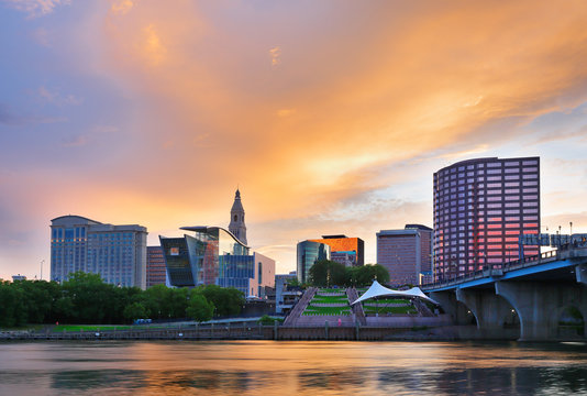 The skyline of Hartford, Connecticut at sunset. Photo shows Founders Bridge and Connecticut River. Hartford is the capital of Connecticut. 
