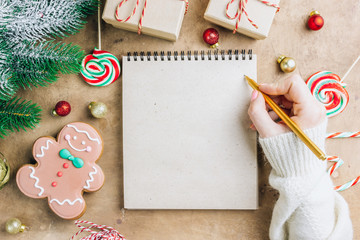 Notebook in the center of cute Christmas decoration: gift box, christmas balls, gingerbread man,...