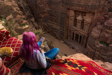 world heritage travel destination photography Middle East Jordan Petra ancient architecture top view girl sitting back to camera on edge of cliff 