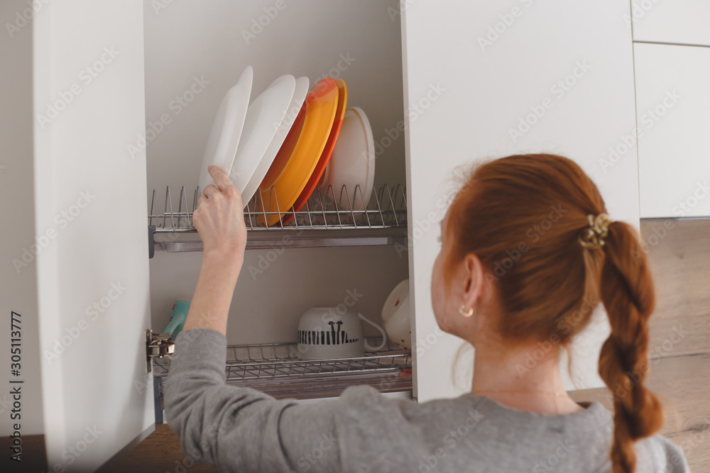 Wall mural Opening kitchen cabinet door, focus on hand opening action