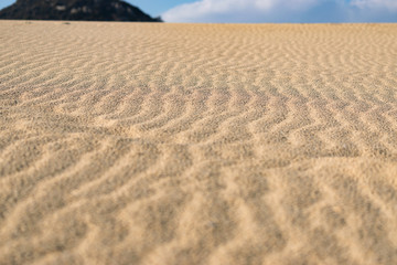 Close up beach sand texture with wavy ripple surface. Summer holiday travel concept.