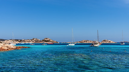 Seascape with yachts moored by the shore of Isola Budelli islet in the area of Sardinia, Italy.