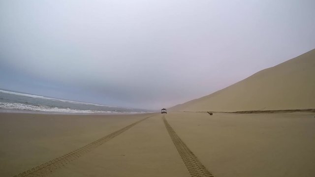 Safari 4x4 driving in the Namib desert by the Atlantic ocean on the skeleton coast, Namibia.