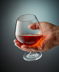 glass of cognac in human hand