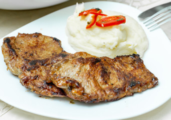 mashed potatoes and fried beef steak in white plate