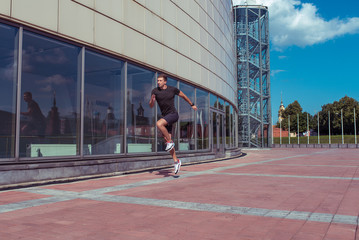 Fototapeta na wymiar Male athlete, summer in the city, training jogging in the jump, morning and afternoon in the city. Sportswear. Motivation and lifestyle of youth. Free space for copy text.