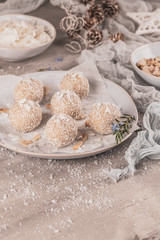 Fototapeta na wymiar Homemade sweet white chocolate and coconut in a plate. Raffaello candy - snowball truffles on a Christmas table.