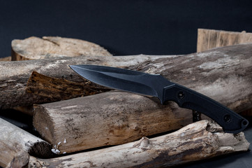 Large knife with a fixed blade. Knife on chopped wood.