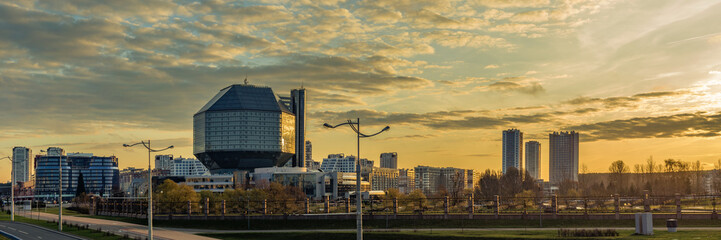 panoramic view of the modern quarter in the area of the national library in Minsk with lateral sunlight from dawn - obrazy, fototapety, plakaty
