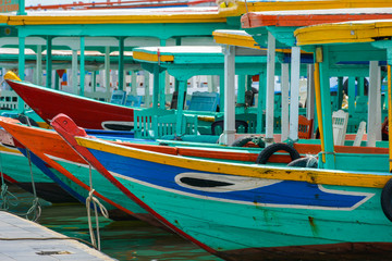 Fototapeta na wymiar Tourist cruises docked along Thu Bon River in Hoi An, Vietnam