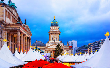 Obraz premium Night Christmas Market of Gendarmenmarkt in Winter Berlin, Germany. German street Xmas and holiday fair. Advent Decoration and Stalls with Crafts Items on the Bazaar.