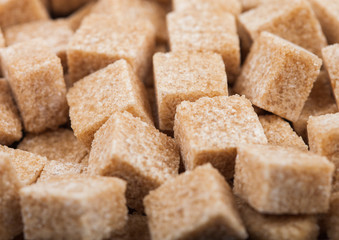 Close-Up shot of natural brown sugar cubes on white background.