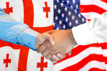 Business handshake on the background of two flags. Men handshake on the background of the Georgia and United States of America flag. Support concept