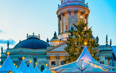Fototapeta premium Night Christmas Market of Gendarmenmarkt in Winter Berlin, Germany. German street Xmas and holiday fair. Advent Decoration and Stalls with Crafts Items on the Bazaar.