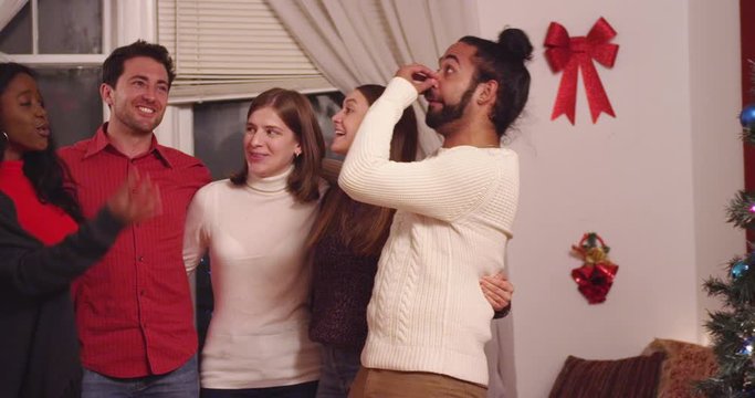 Friends singing carols and drinking wine at a holiday party - slow motion - shot on RED