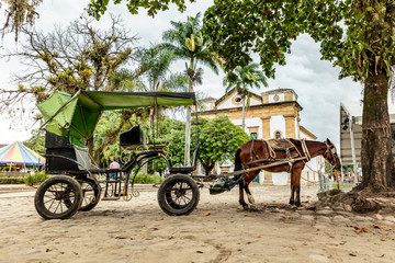 Horse and carriage on the cobblestone street in the historic center in Paraty, Rio de Janeiro, Brazil. UNESCO World Heritage Site on the Brazilian Coast