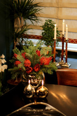Modern Lifestyle Contemporary Vase with Red Flowers and Round and Golden Candlesticks on Wooden Table with Window Background