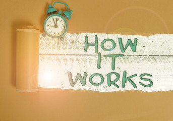 Handwriting text writing How It Works. Conceptual photo Used to asked about on What Way or analysisner By What Means Alarm clock and torn cardboard placed above a wooden classic table backdrop