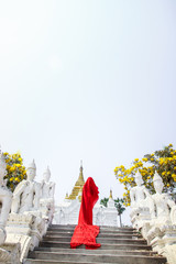 Creature in a red floaty robe walking along ancient Myanmar Buddhist temples and stupas experimental shoot