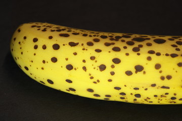 Tokyo,Japan-November 24, 2019: Closeup of a ripe banana with dark spots on black background