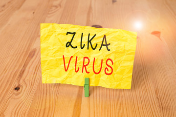 Conceptual hand writing showing Zika Virus. Concept meaning caused by a virus transmitted primarily by Aedes mosquitoes Wooden floor background green clothespin groove slot office